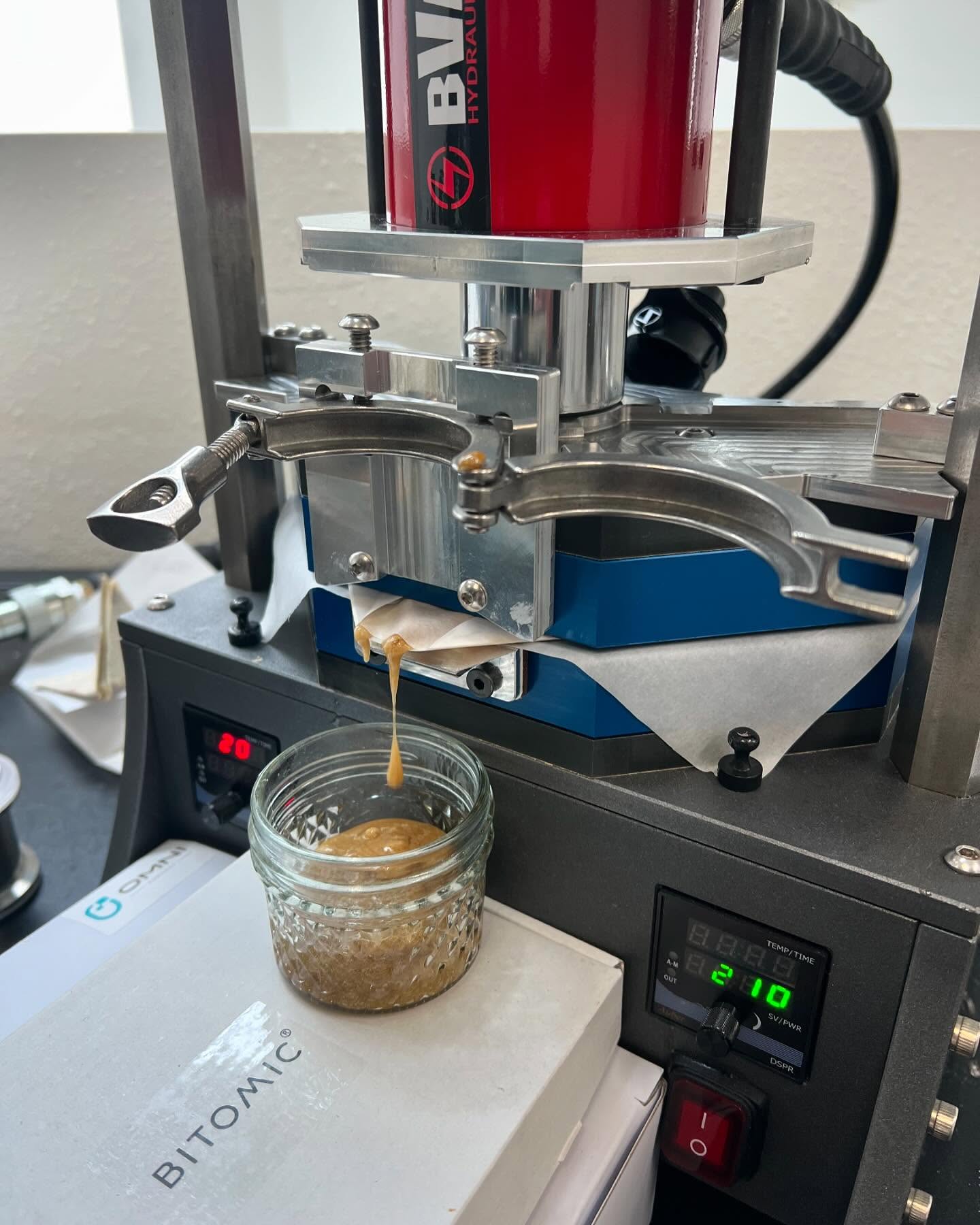 KWÄD press mid-run: rosin flowing from the filter cup onto parchment